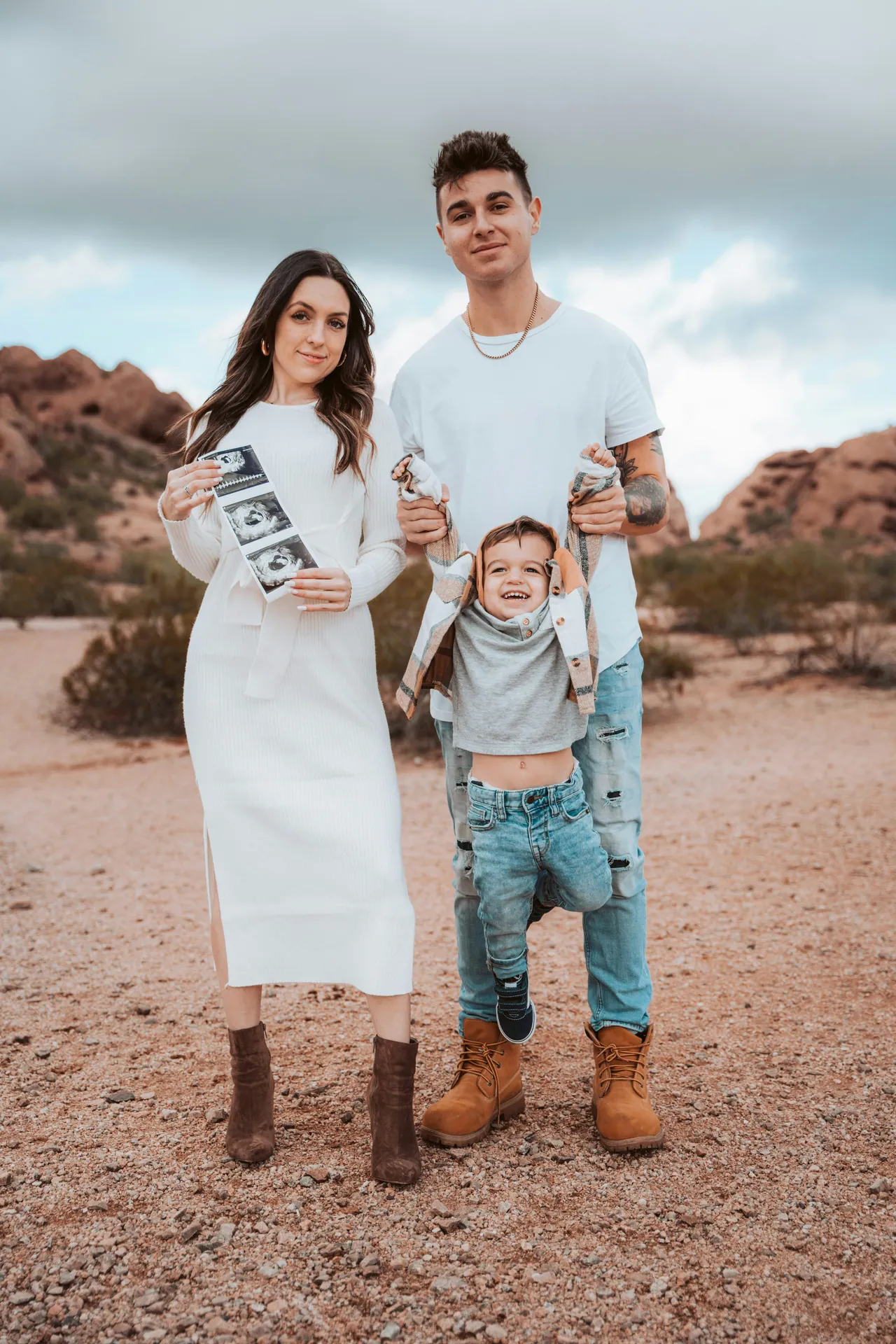 Expectant parents and their toddler in the desert
